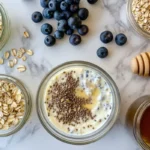 Overhead shot of a prepared overnight oats recipe in a mason jar with fresh berries on top.